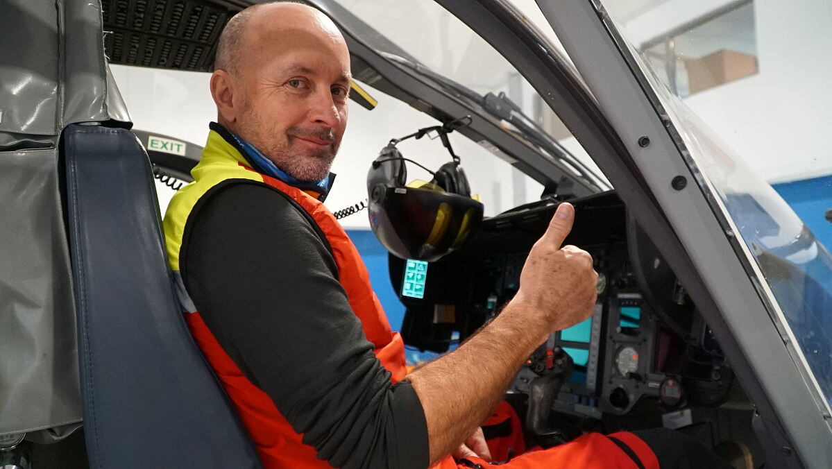 Gisbert Strolz posiert für ein Foto in seinem Helikopter